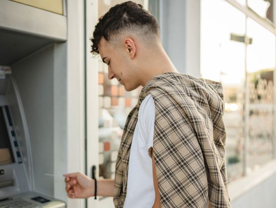 Junge benutzt Geldautomat