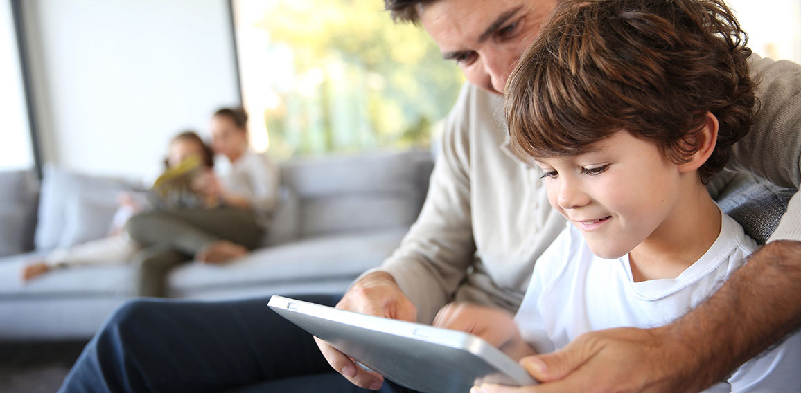 Familie in Wohnzimmer verwendet Tablet