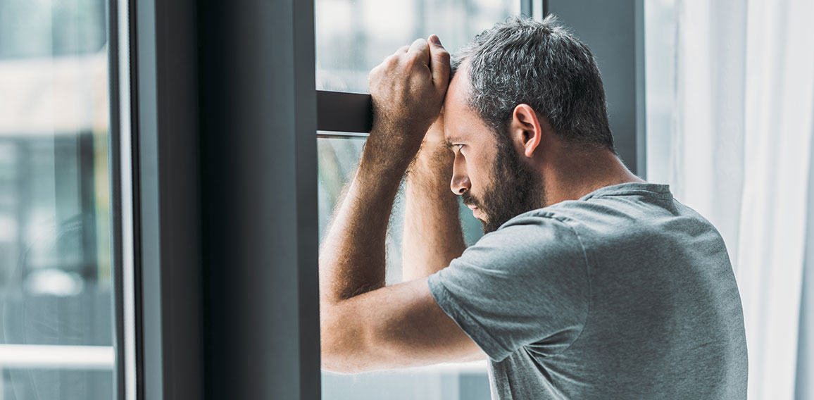 Trauriger Mann an Fenster