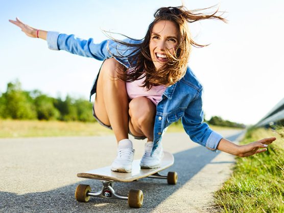 Lächelnde Frau auf Longboard