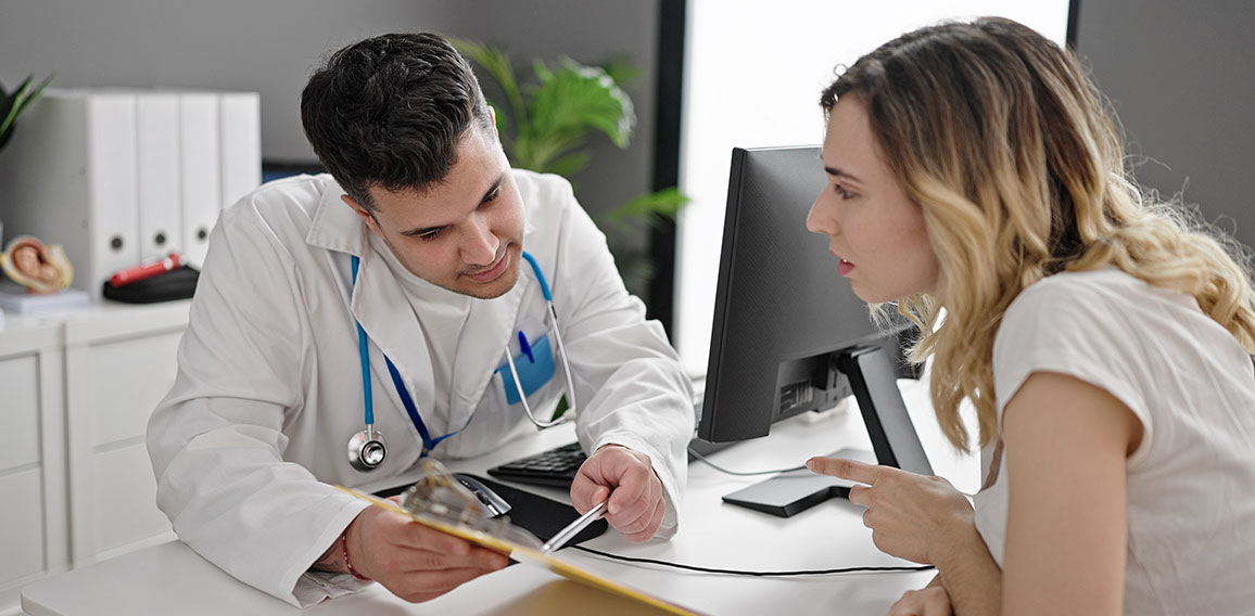 Man and woman doctor and patient having consultation showing medical report at clinic