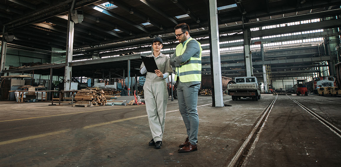 Inspector on tour in large metal industry factory.