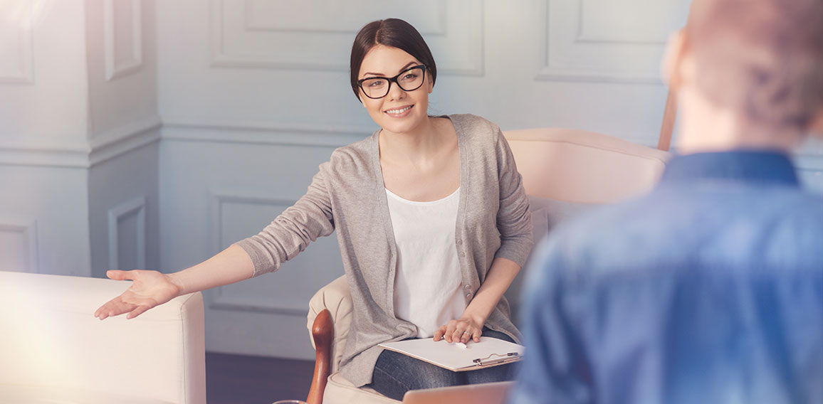 Cheerful school psychologist going to talk with a teen boy