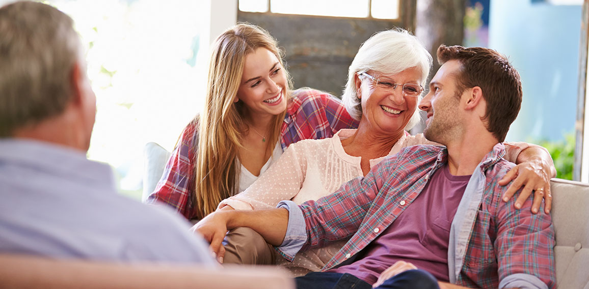 Family With Adult Children Relaxing On Sofa At Home Together