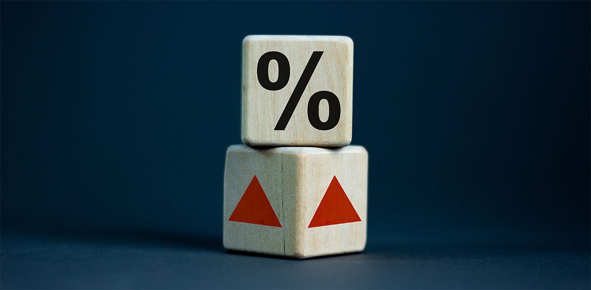 Wooden cubes changes the direction of an arrow symbolizing that the interest rates are going down or vice versa . Business concept. Copy space, beautiful grey background.