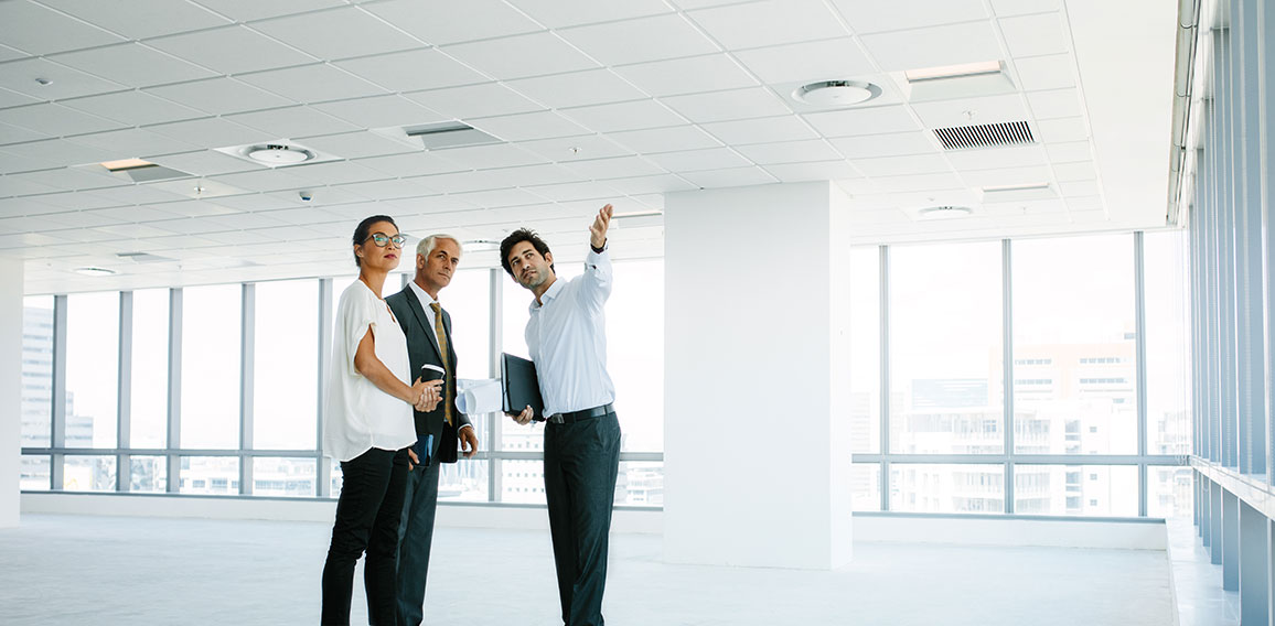 Real estate agent showing new office space to clients