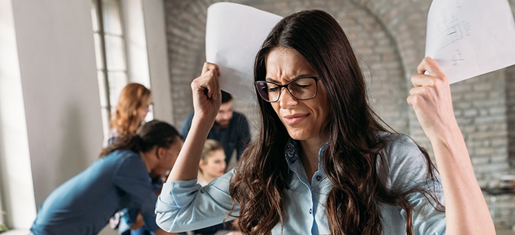 Picture of angry overworked businesswoman in office