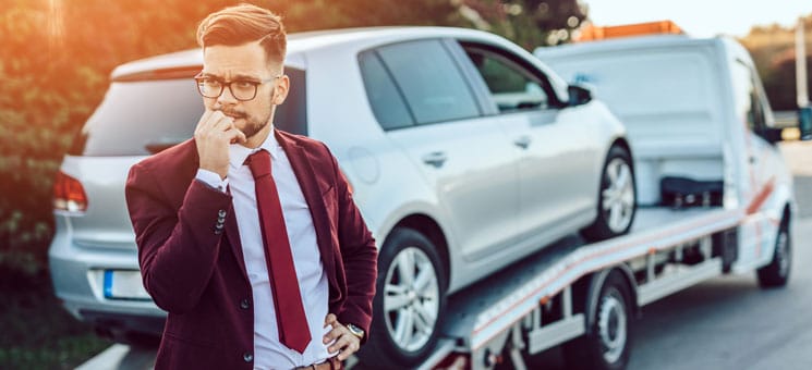 Elegant middle age business man using towing service for help ca