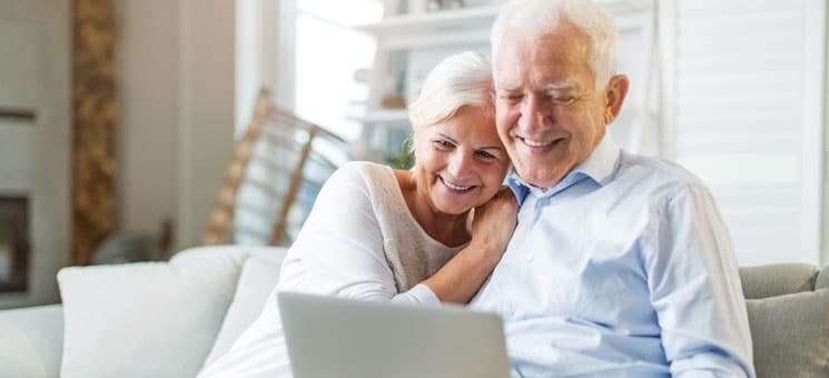 Senior couple using laptop computer at home