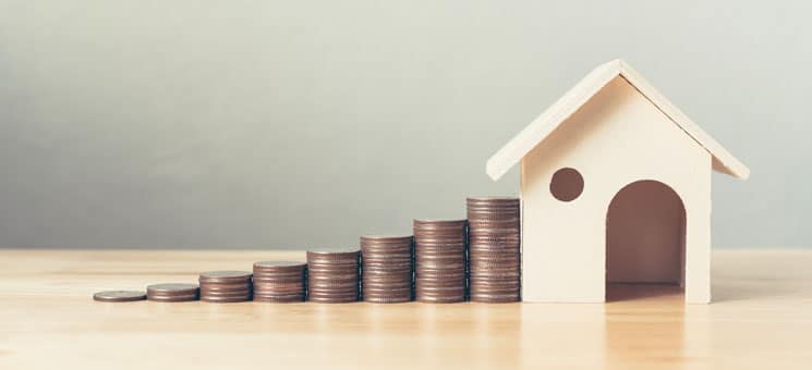 Property investment and house mortgage financial concept, Hand putting money coin stack with wooden house