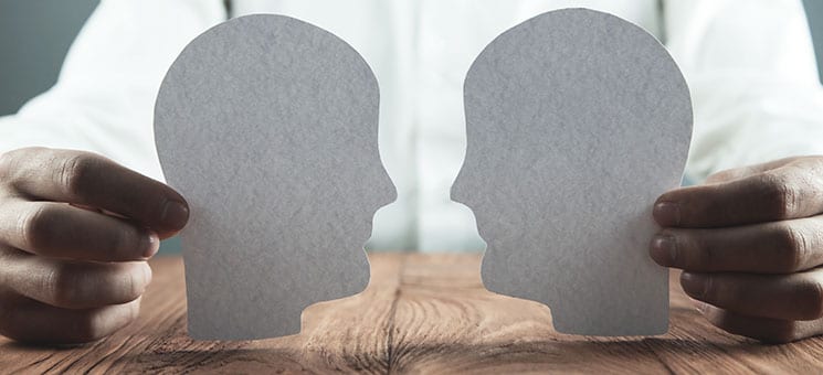 Businessman showing paper human heads on wooden desk. Business c