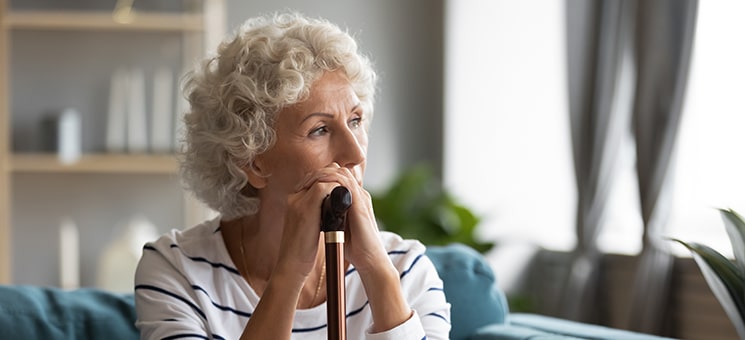 Pensive disabled old lady look in distance mourning