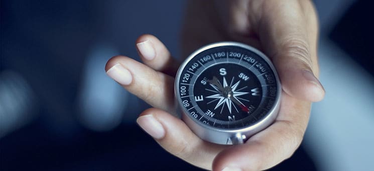 Businessman with a compass holding in hand, color tone film look