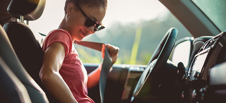 Woman driver buckle up the seat belt before driving car