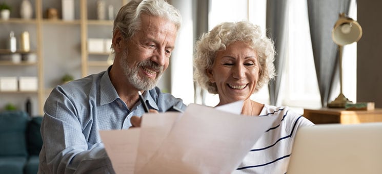 Senior couple use online banking on laptop planning family budget