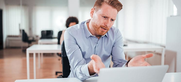 Annoyed business man looking at laptop screen.