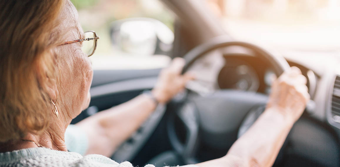 Elderly woman behind the steering wheel of a car