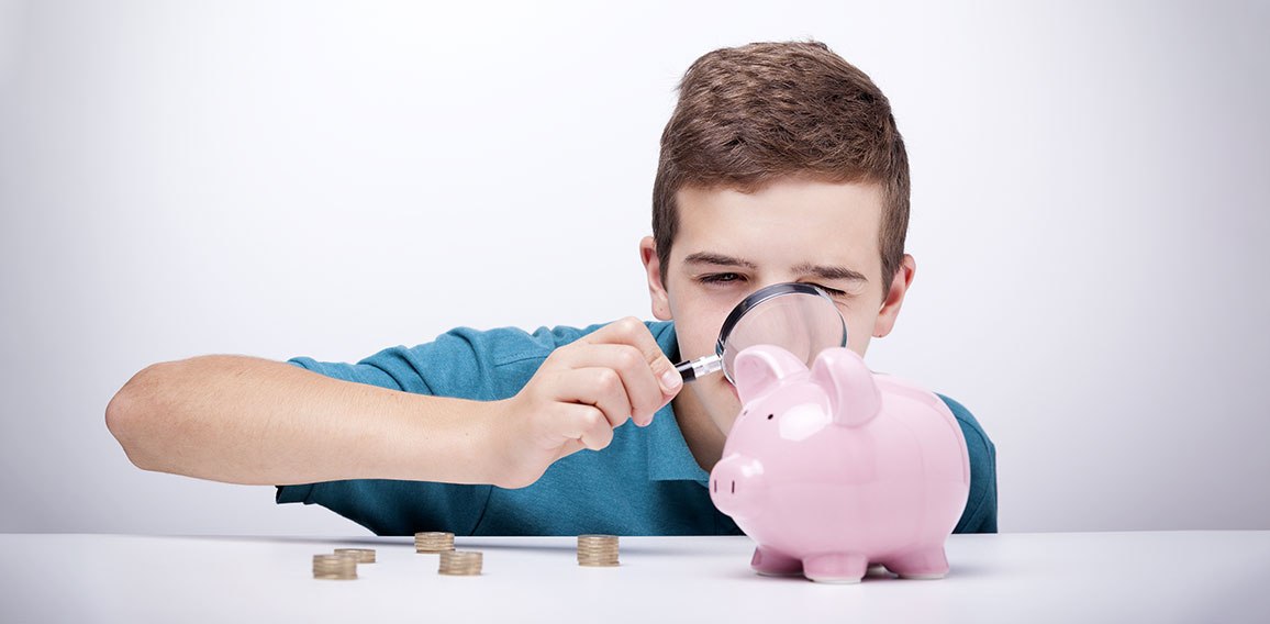 Boy with magnifying glass looking to his savings