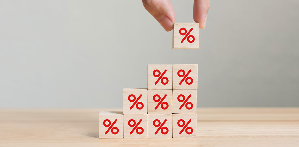 Interest rate financial and mortgage rates concept. Hand putting wood cube block increasing on top with icon percentage symbol upward direction