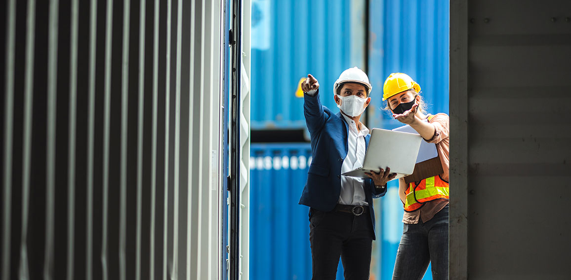 Business executives and engineers wear medical face masks. While inspecting industrial plants and container yard warehouses for international shipping businesses Concepts of import and export via airplanes and ships