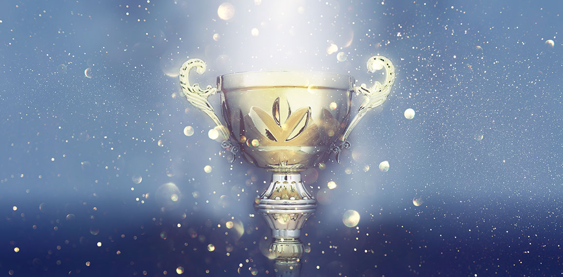 sports concept low key image of gold trophy over dark smoky background and glitter lights