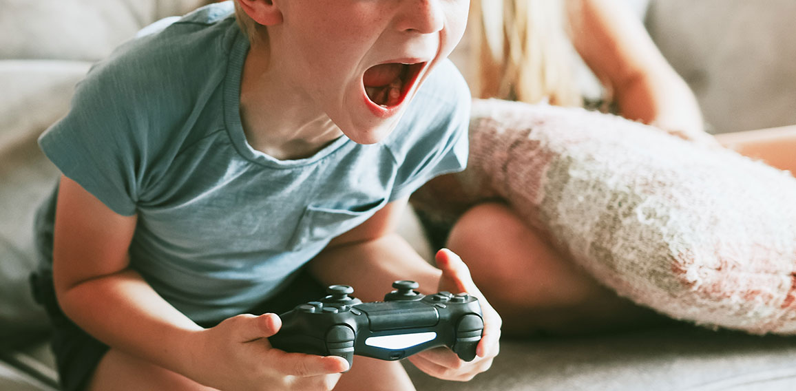 Young boy playing video game in living room