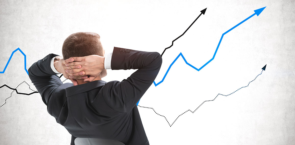 Confident businessman looking at rising graphs