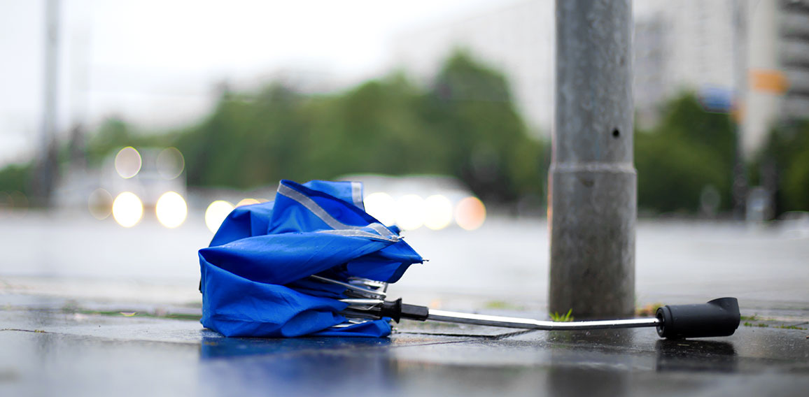 After a strong storm a broken umbrella is lying on the street