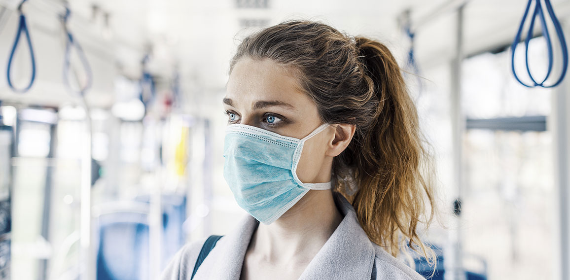 Woman wearing surgical protective mask in a public transportatio