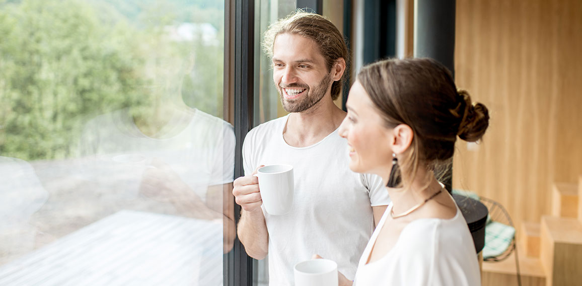 Couple standing near the window indoors