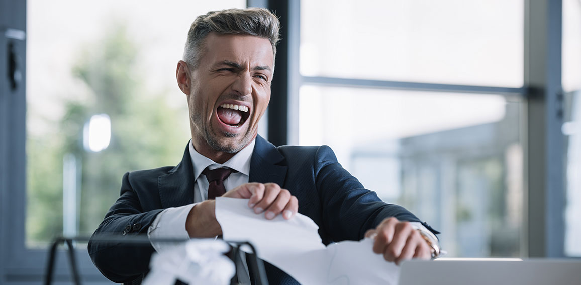 selective focus of irritated man tearing paper in office