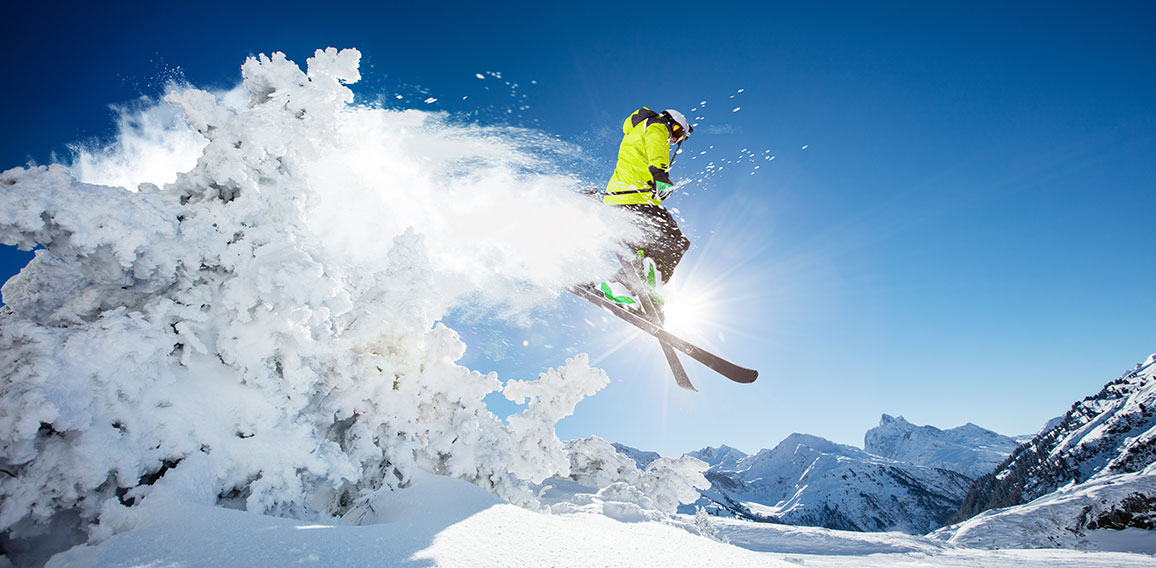 Skier at jump in Alpine mountains