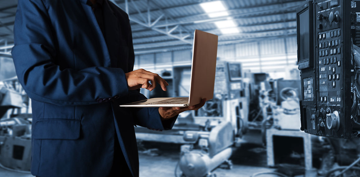 Manager Industrial Engineer in the suit uses Laptop Computer wit