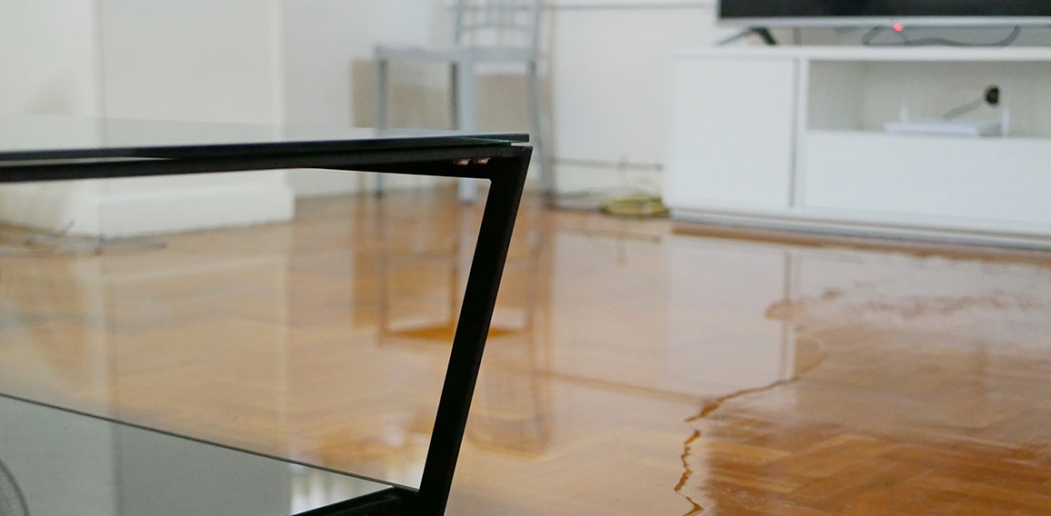 Close up of water flooding on living room parquet floor in a hou