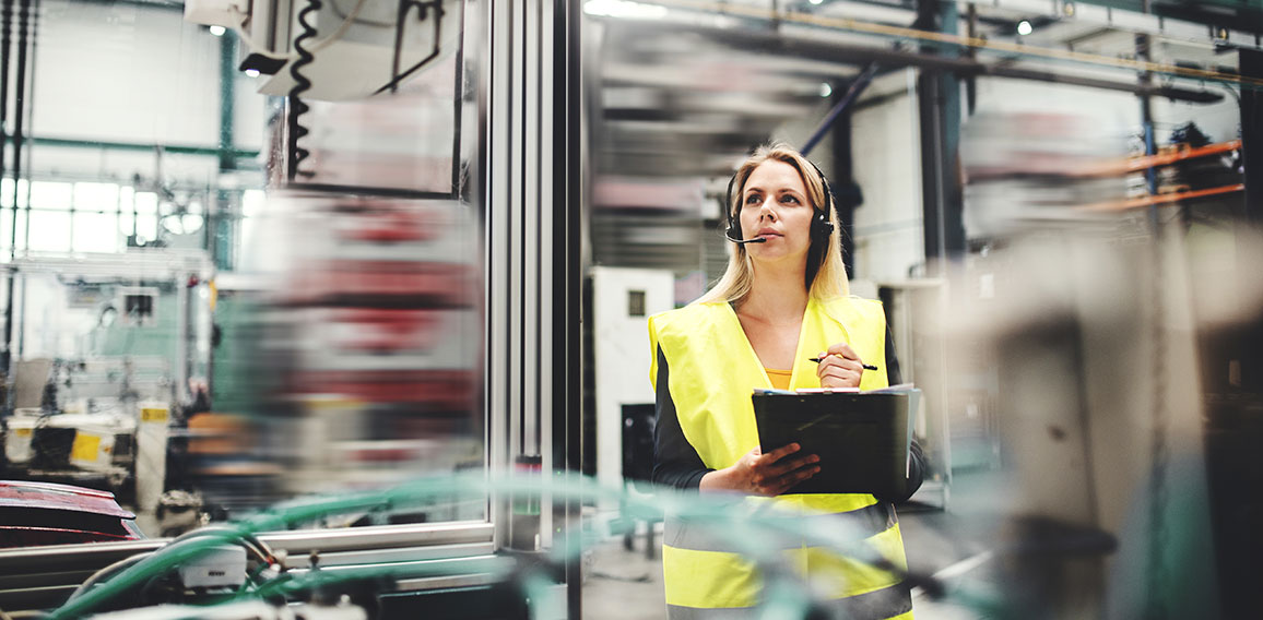 Industrial woman engineer with headset in a factory, working. Copy space.