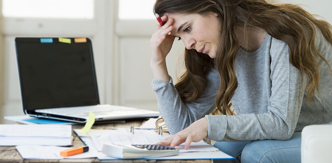 worried woman suffering stress doing domestic accounting paperwo