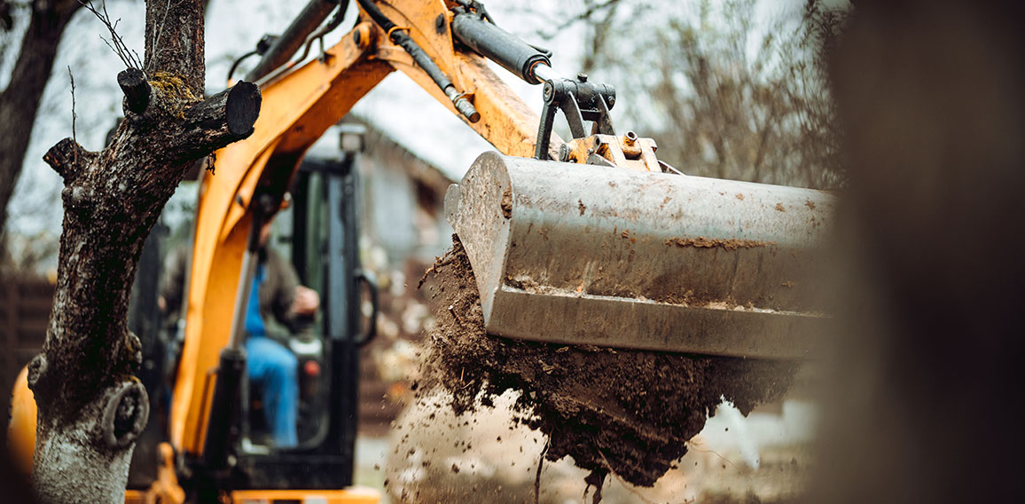 Worker using excavator and bulldozer for landscaping works