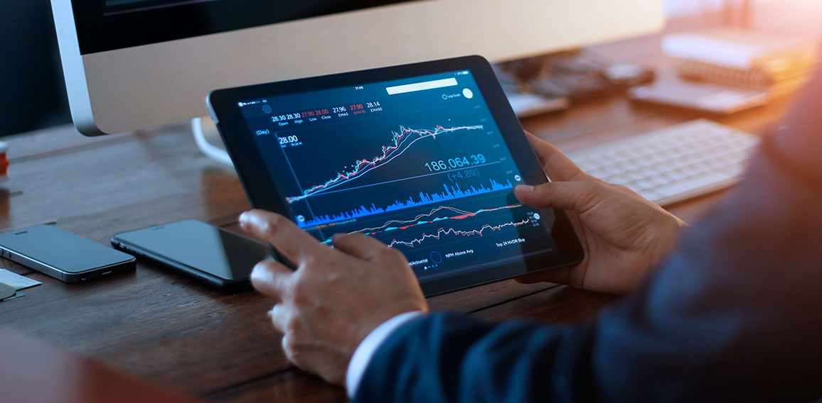 Businessman checking stock market on digital tablet and a deskto