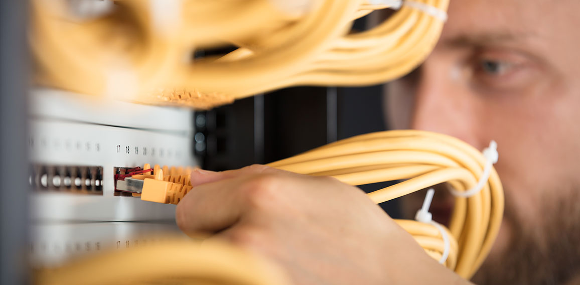 Engineer Plugging Cables Into Server