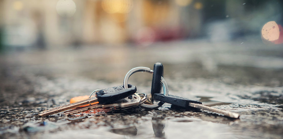 Set of lost keys on the ring on wet ground on the street