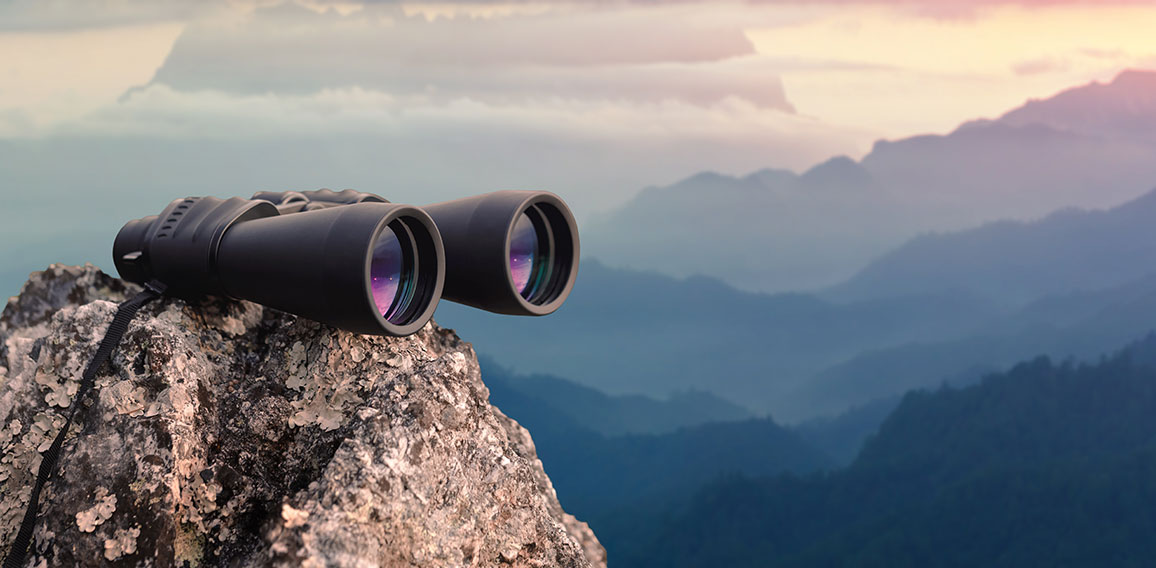 Binocular on top of rock mountain at sunset