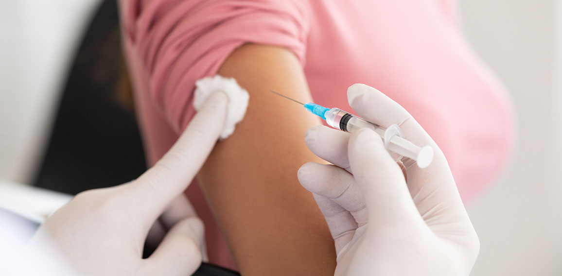 Male doctor doing vaccination to young woman