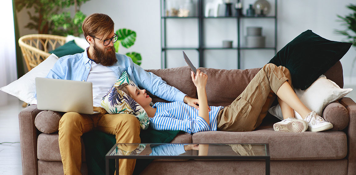 happy couple relaxing at home with laptop and tablet