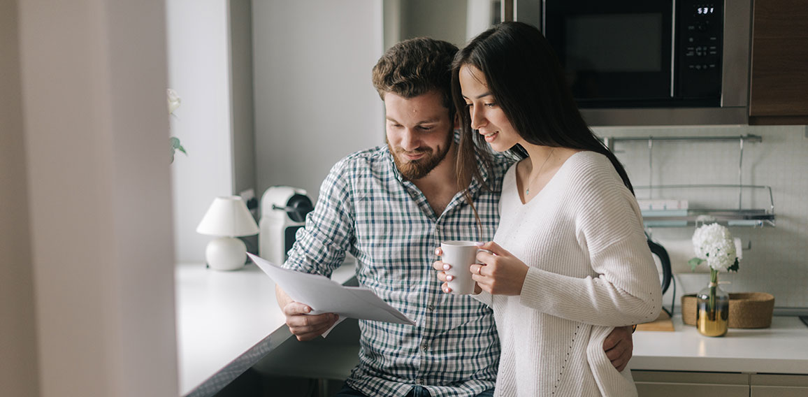 Attractive young married couple ouple studying mortgage documents together