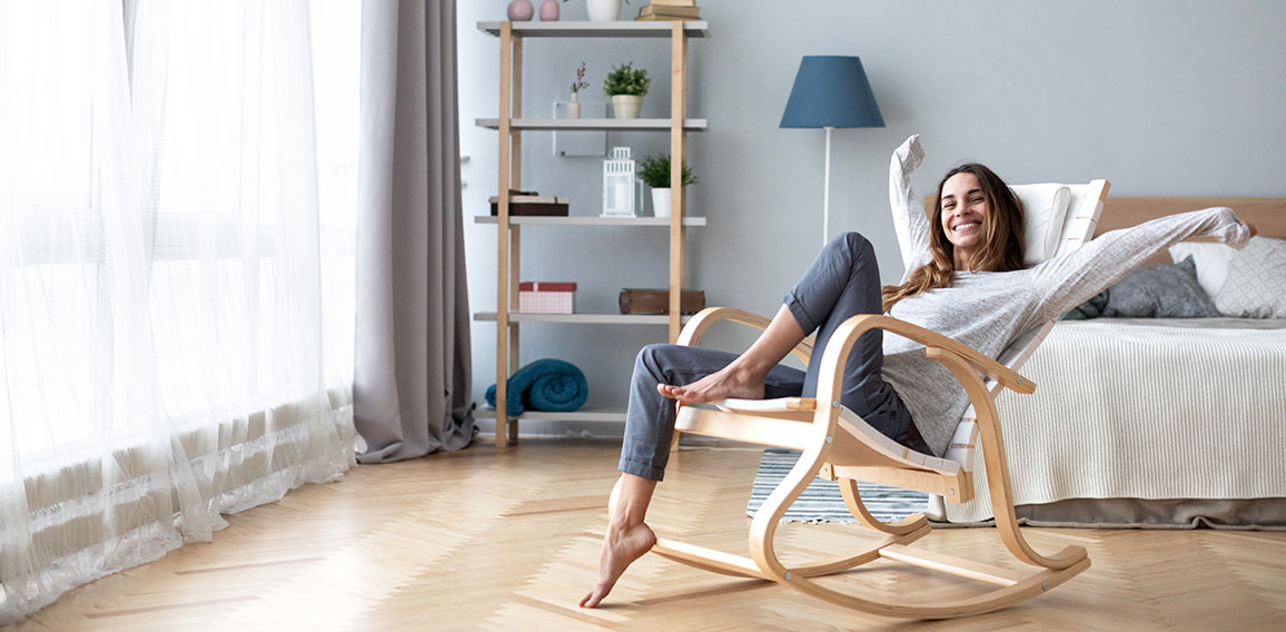 Happy woman resting comfortably sitting on modern chair in the l