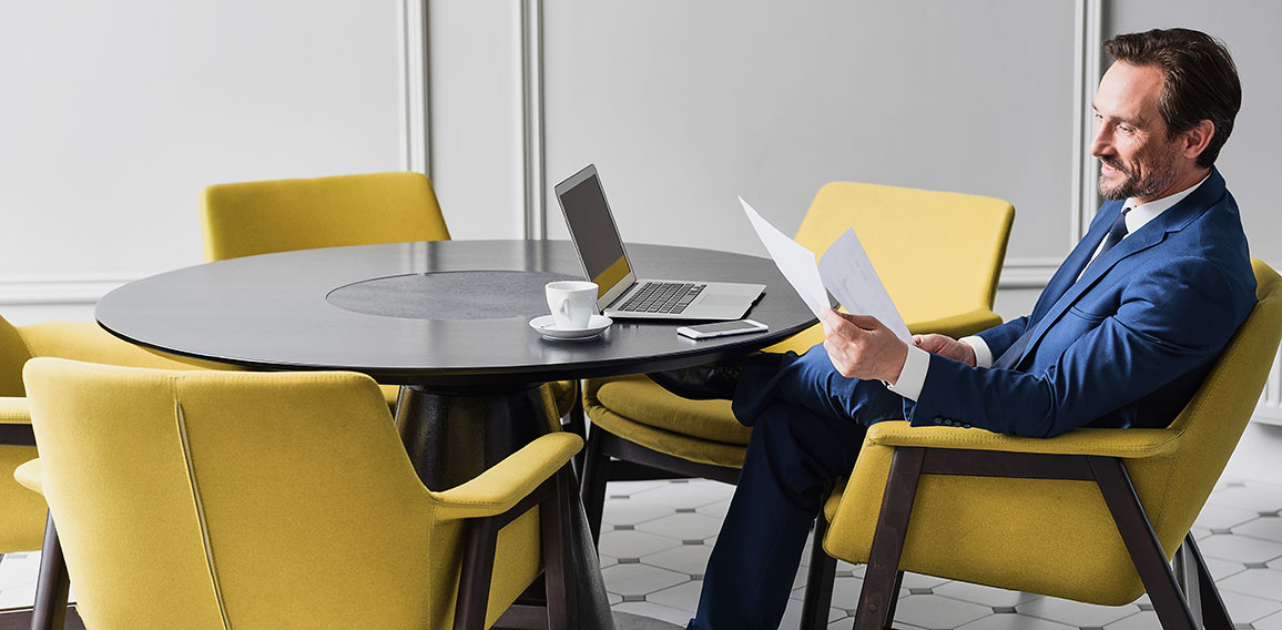 Happy male manager working with papers in cozy office