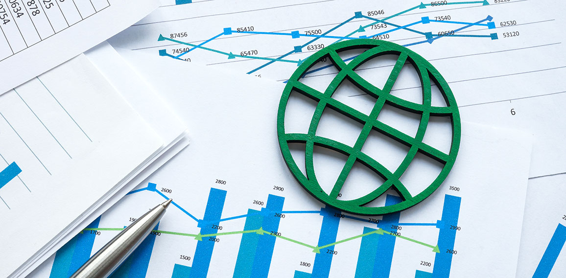 ESG concept. The green symbol of the globe lies on financial papers.