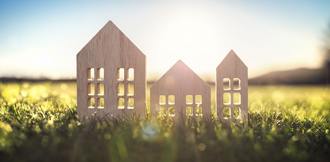 Ecological wood  model house in empty field at sunset