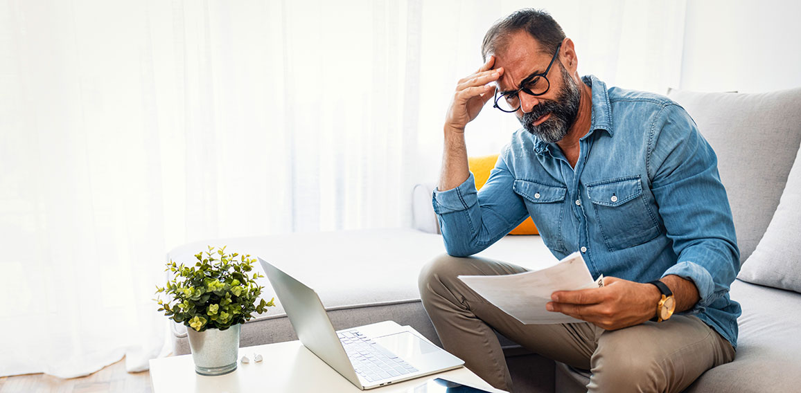 Confused frustrated mature man holding mail letter and money, re