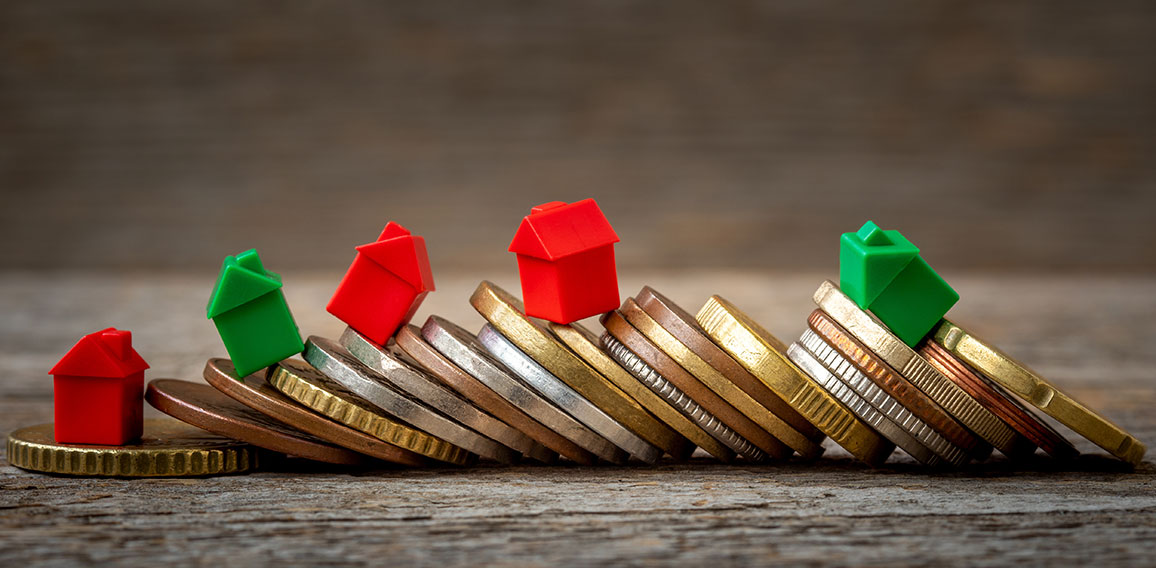 Pile of coins and miniature house models